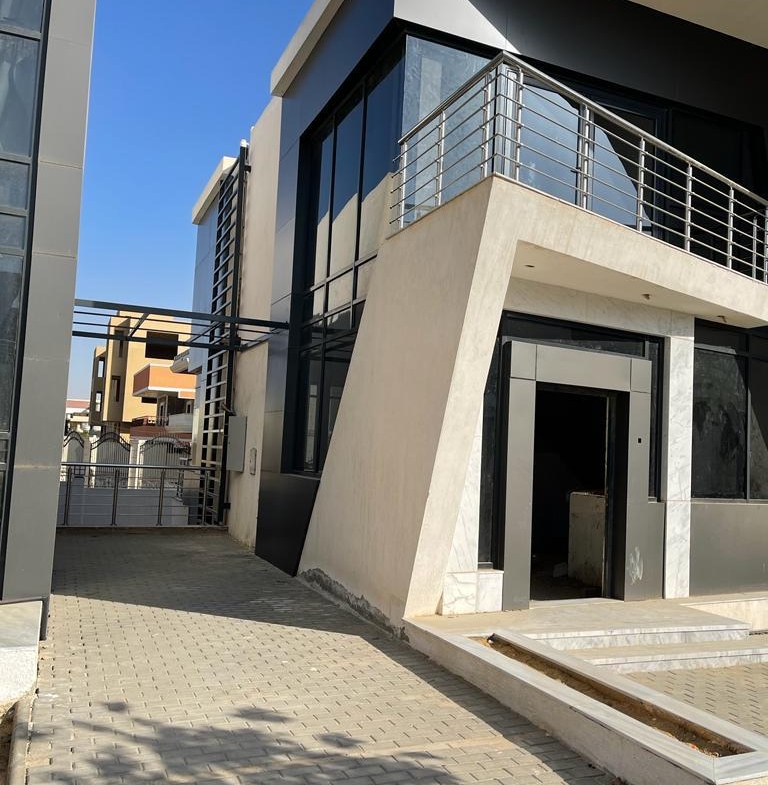 Side of a modern villa with a glass wall and a balcony - villa in Life View, New Cairo