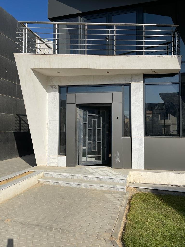 property-image-69f0d6d5b9583 باب فيلا أمامي تحت بلكونة بدرابزين معدن - فيلا في لايف فيو، القاهرة الجديدة