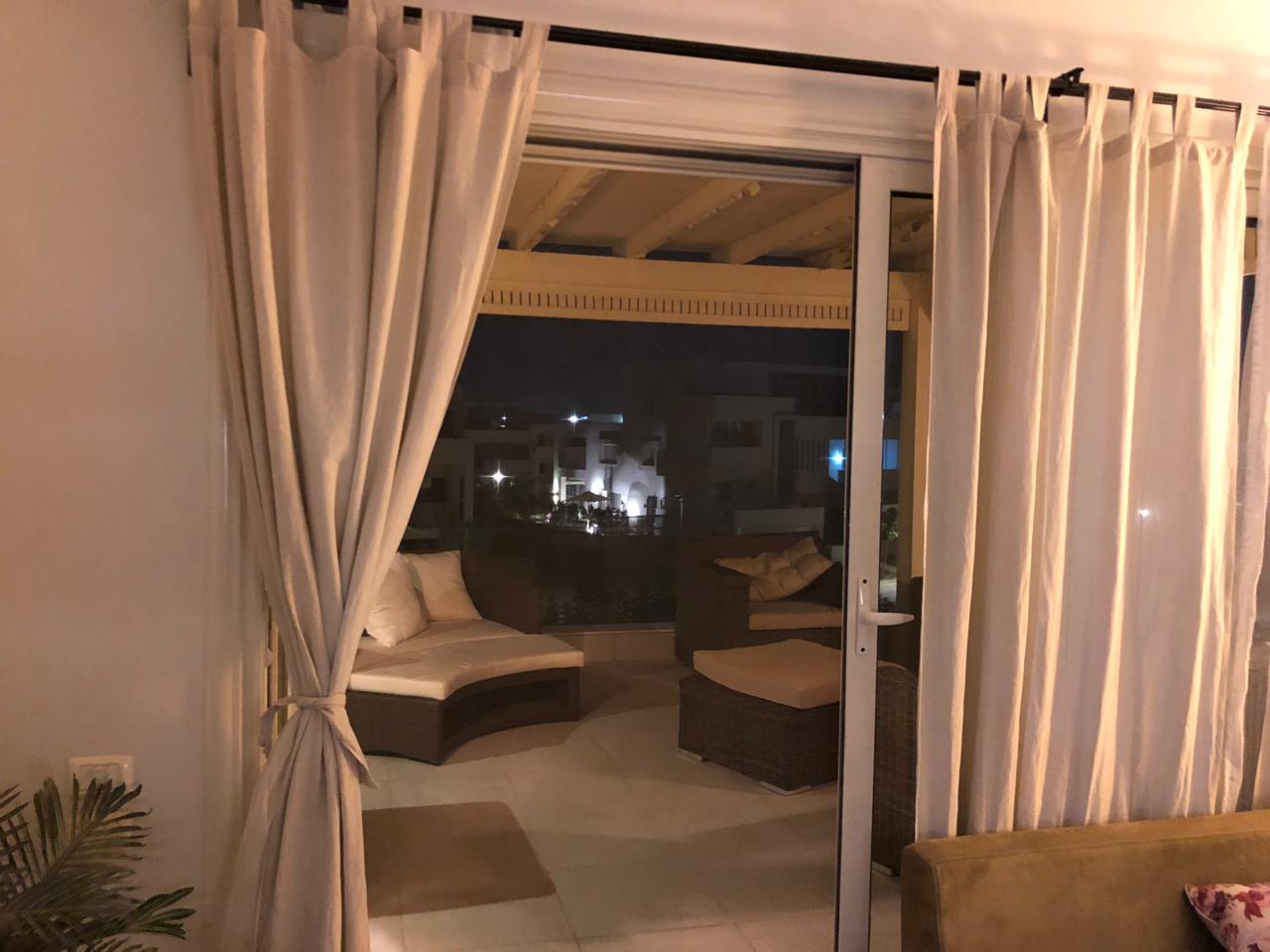 property-image-69f0d9af35bd2 جلسة بستائر كريمي تفتح على التراس ليلا - شاليه في هاسيندا باي، الساحل الشمالي