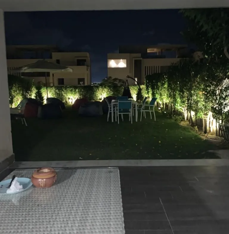 Night garden with wall lights and paved patio - townhouse in Hacienda Bay, North Coast