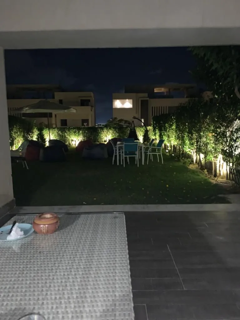 Night garden with wall lights and paved patio - townhouse in Hacienda Bay, North Coast