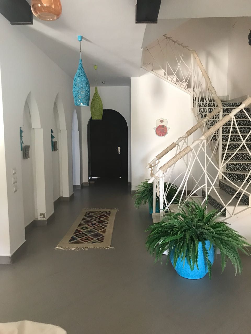 Entrance hall with arched doorway and a spiral staircase - townhouse in Hacienda Bay, North Coast