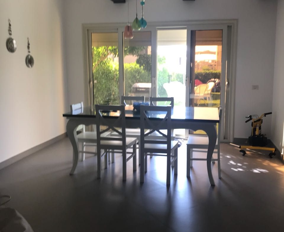 Dining table with dark chairs and a terrace door - townhouse in Hacienda Bay, North Coast