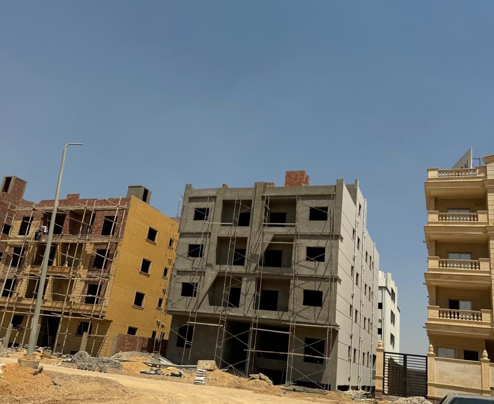 Residential blocks under construction beside a sandy street - apartment in Bayt Al Watan, New Cairo