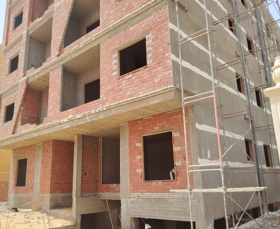Red brick apartment building shell with open window frames - apartment in Bayt Al Watan, New Cairo