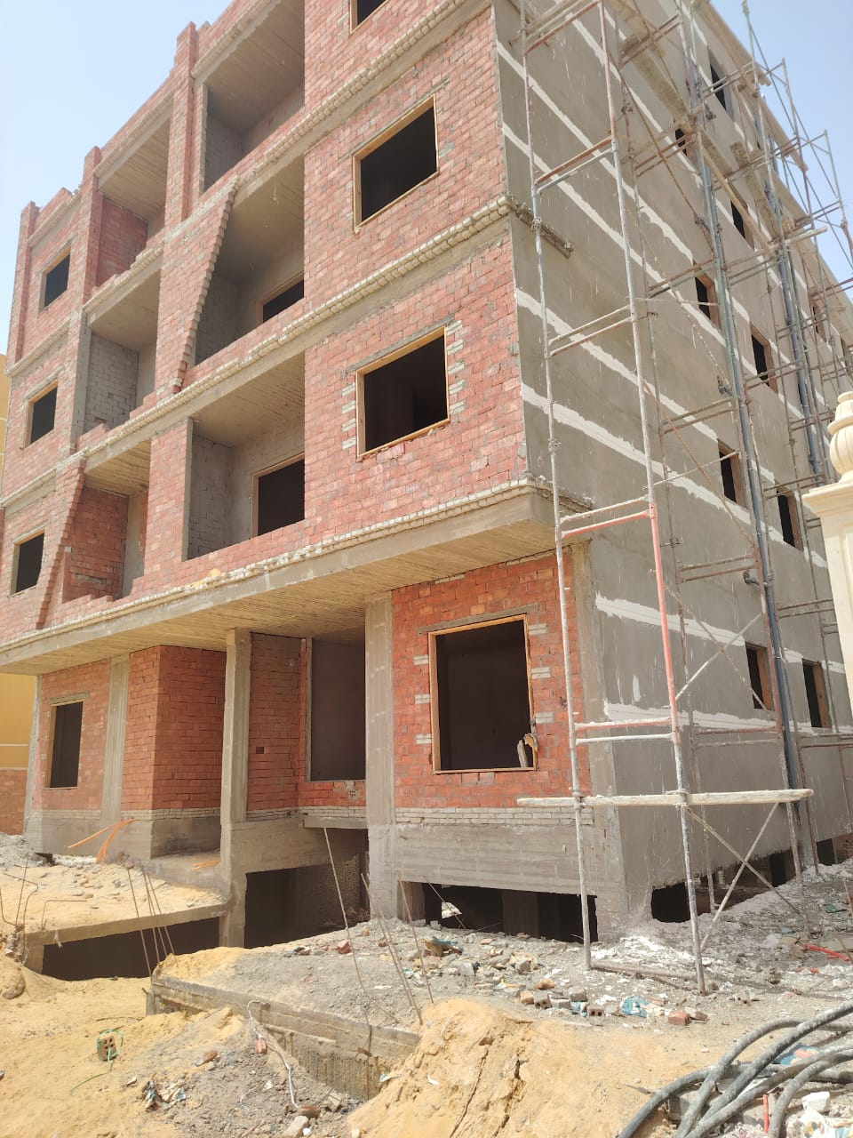 Red brick apartment building shell with open window frames - apartment in Bayt Al Watan, New Cairo