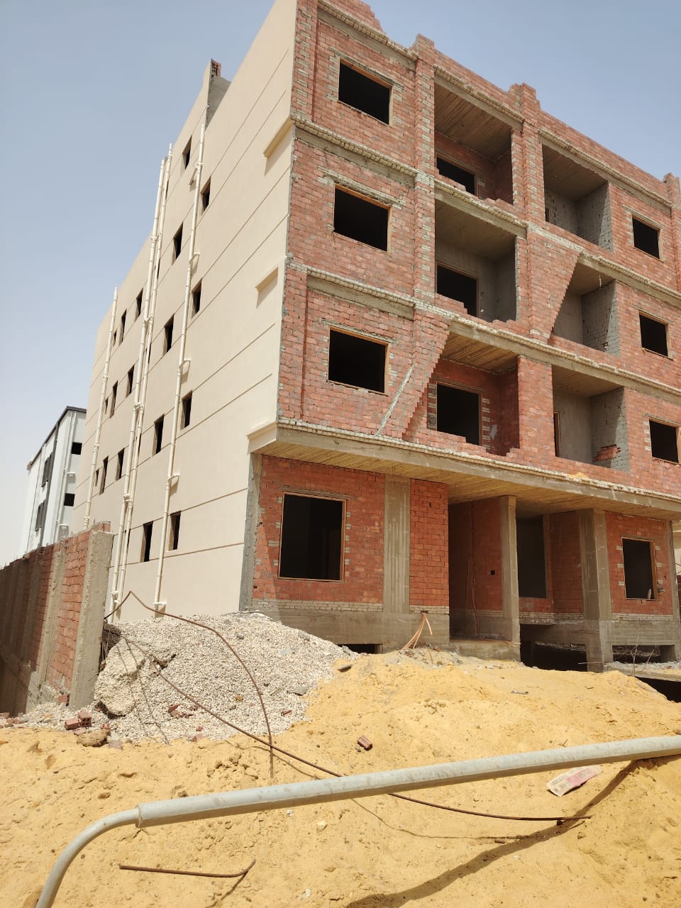 Apartment building shell with brick and plaster on a sandy lot - apartment in Bayt Al Watan, New Cairo