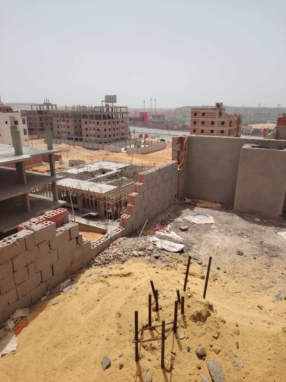 Construction site with rebar and neighbouring buildings - apartment in Bayt Al Watan, New Cairo