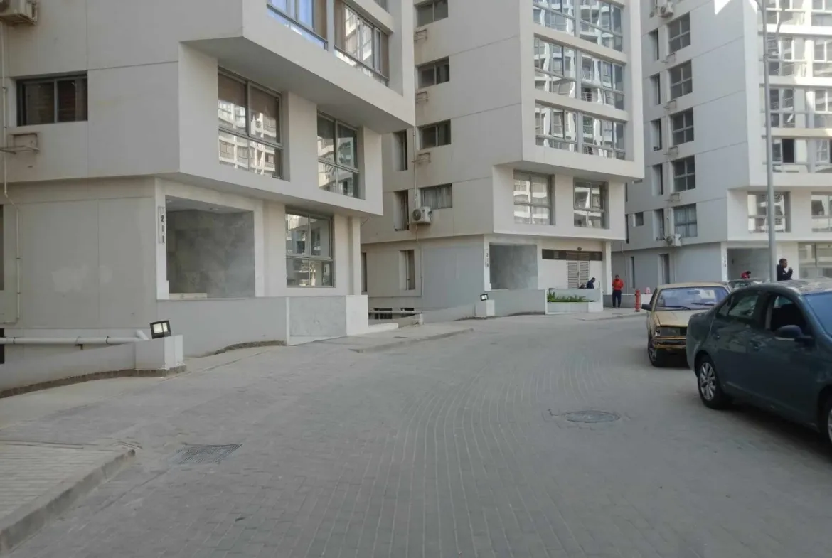 طريق فناء بين عمارات سكنية وسيارة واقفة - شقة في كمبوند ون قطامية، القاهرة الجديدة