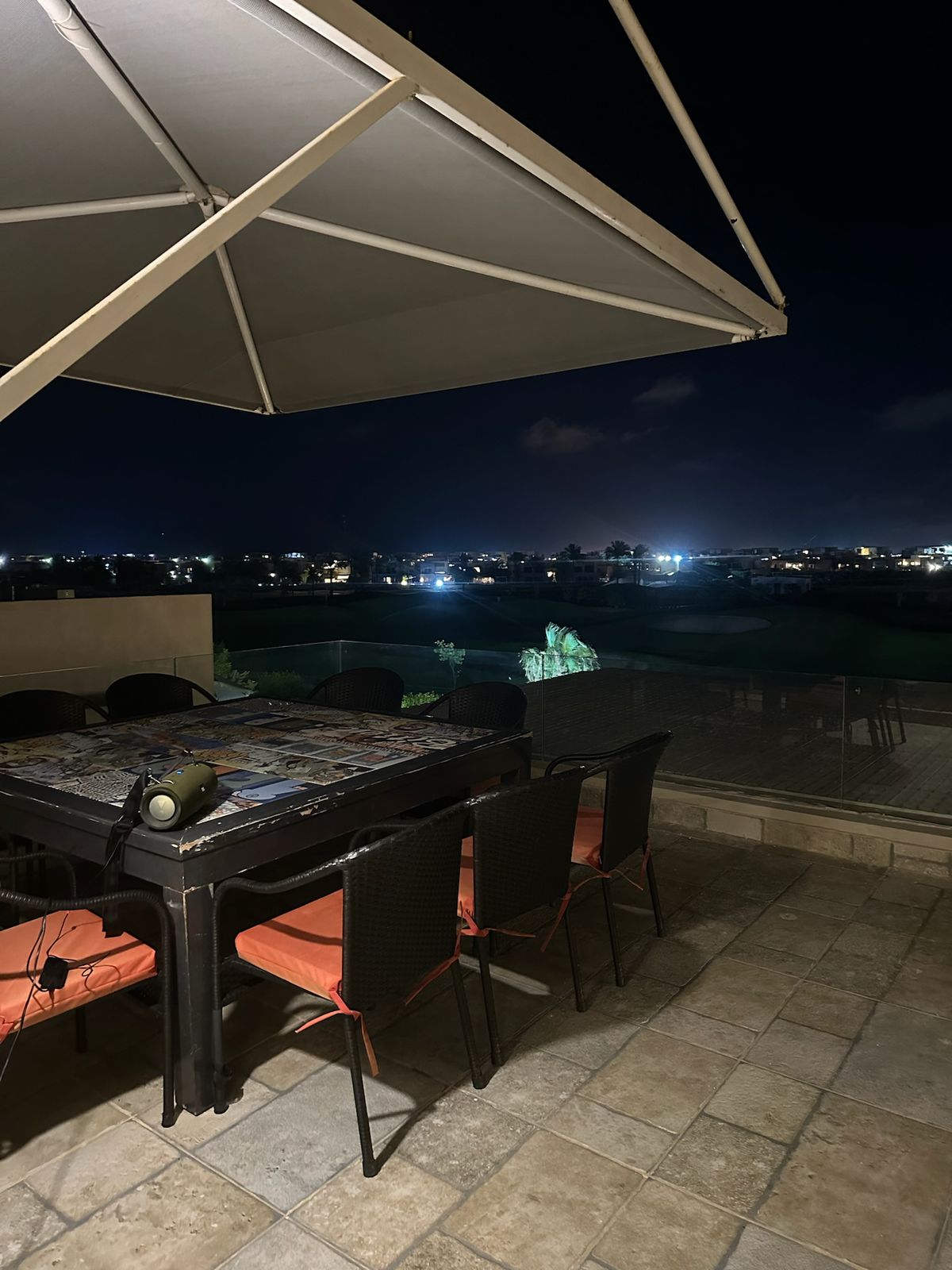 Outdoor dining table with orange chairs under a large parasol - chalet in Hacienda Bay, North Coast