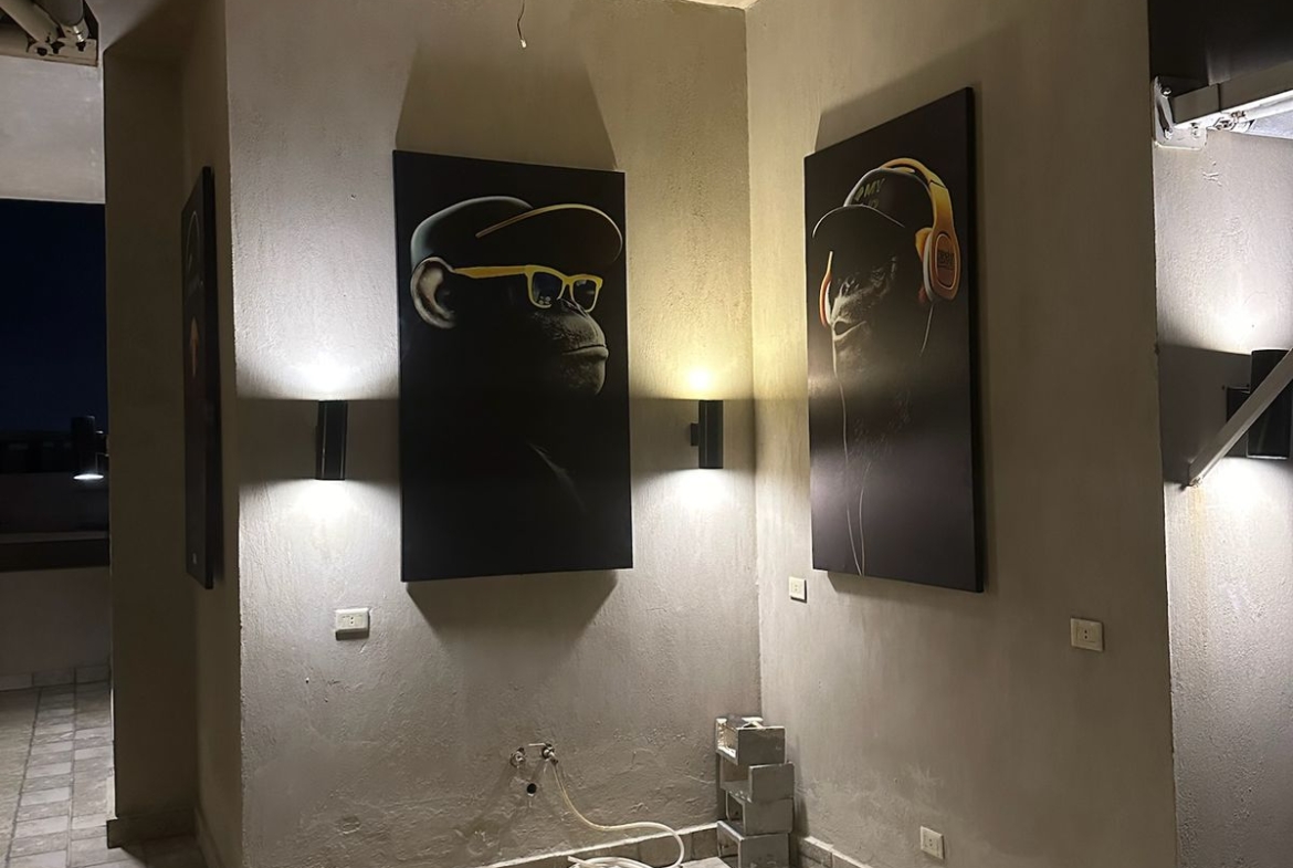 Wall-lit corner with framed art on the terrace - chalet in Hacienda Bay, North Coast