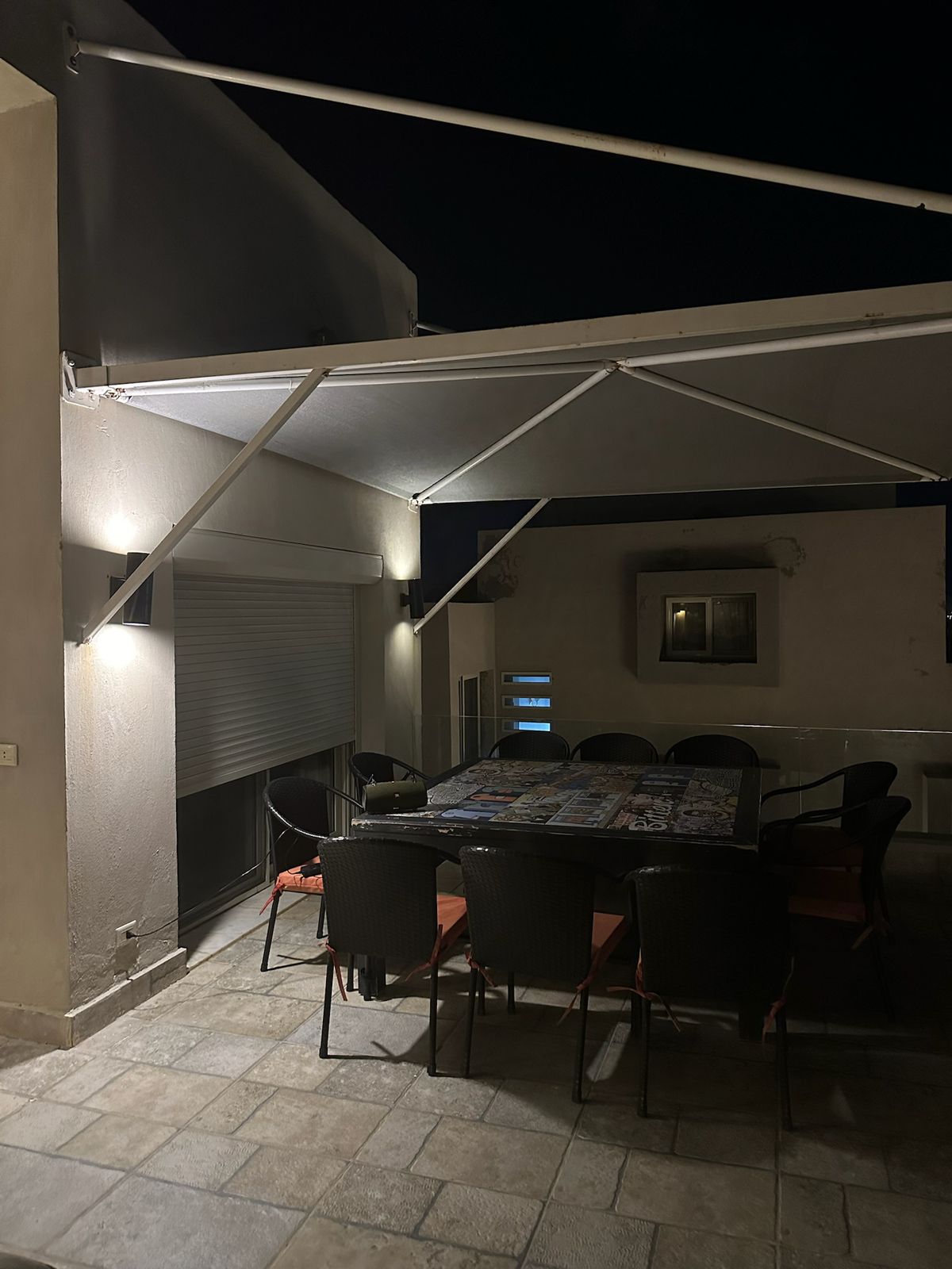 Dining set under a canopy on the roof at night - chalet in Hacienda Bay, North Coast