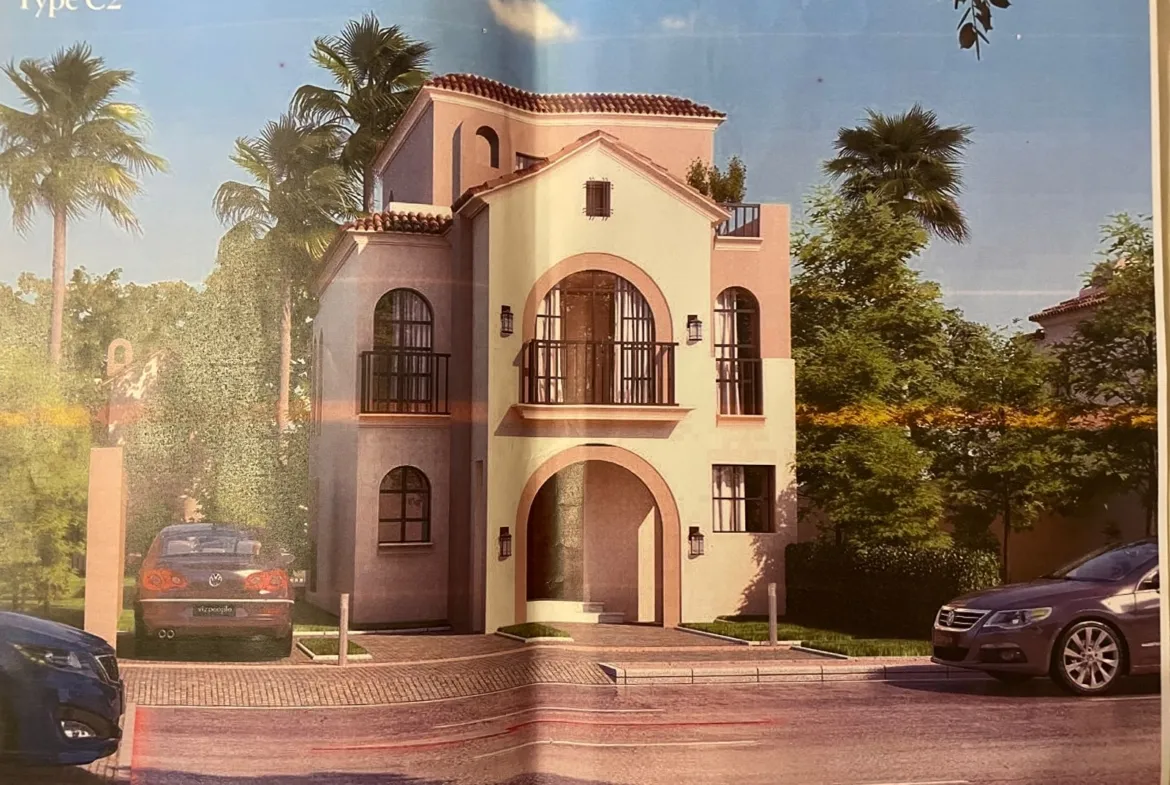 Brochure photo of a Mediterranean villa with an arched entrance and palms - villa in Sarai Cavana Lakes, Mostaqbal City