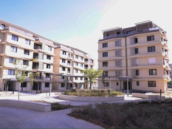 صورة حقيقية عامة لمباني باديا، وليست الشقة أو إطلالتها. General real Badya community building photograph, not the listed apartment or its view.