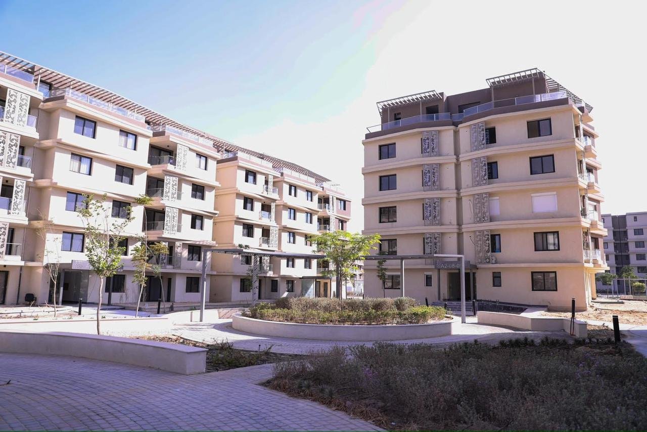 صورة حقيقية عامة لمباني باديا، وليست الشقة أو إطلالتها. General real Badya community building photograph, not the listed apartment or its view.