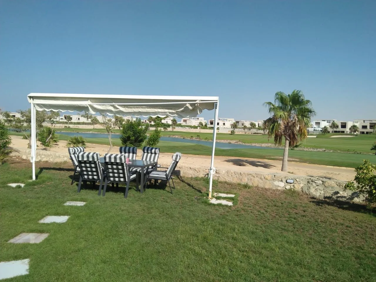 Garden dining set under a white canopy beside the golf course - chalet in Hacienda Bay, North Coast