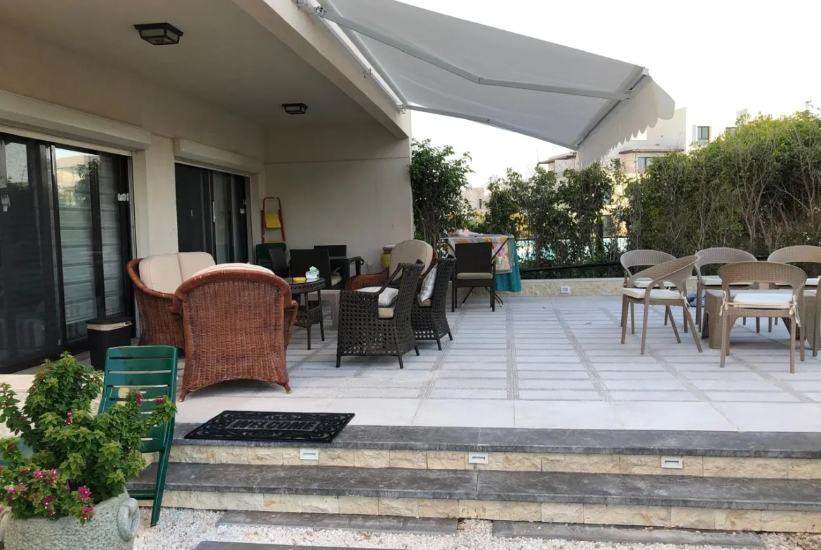 Terrace with wicker armchairs under a retractable awning - chalet in Marassi Blanca, North Coast