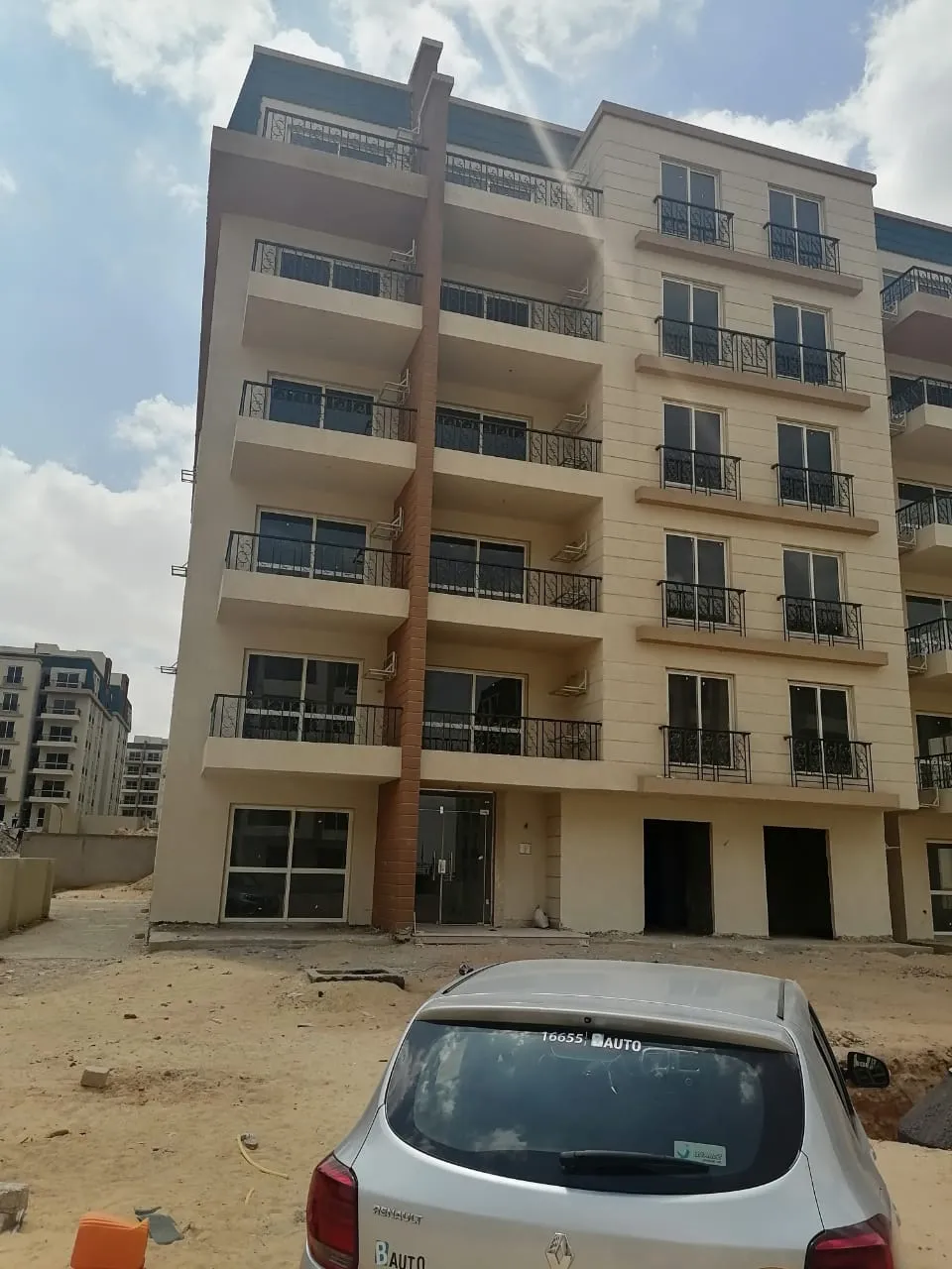 1-01-1124-source-04 عمارة تحت التشطيب وسيارة أمامها - شقة في نيوبوليس، القاهرة