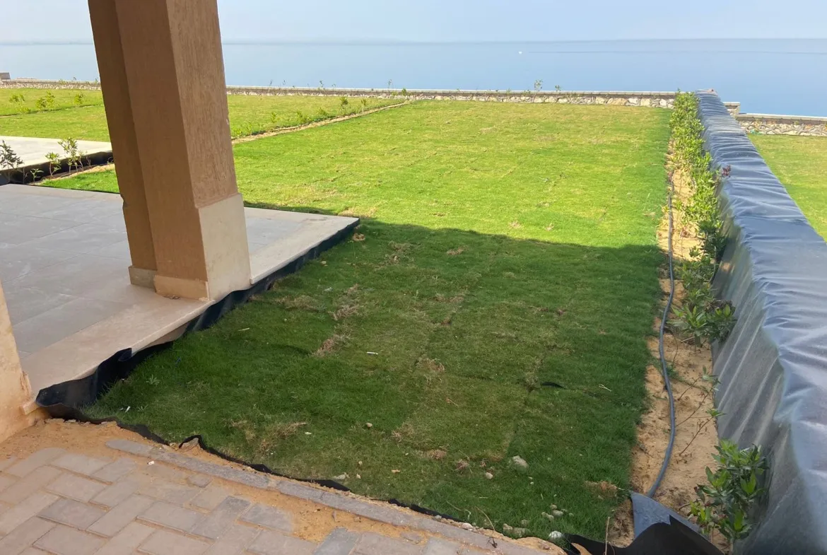 مسطح أخضر بجوار تراس مغطى يطل على البحر - توين هاوس في تلال بالعين السخنة