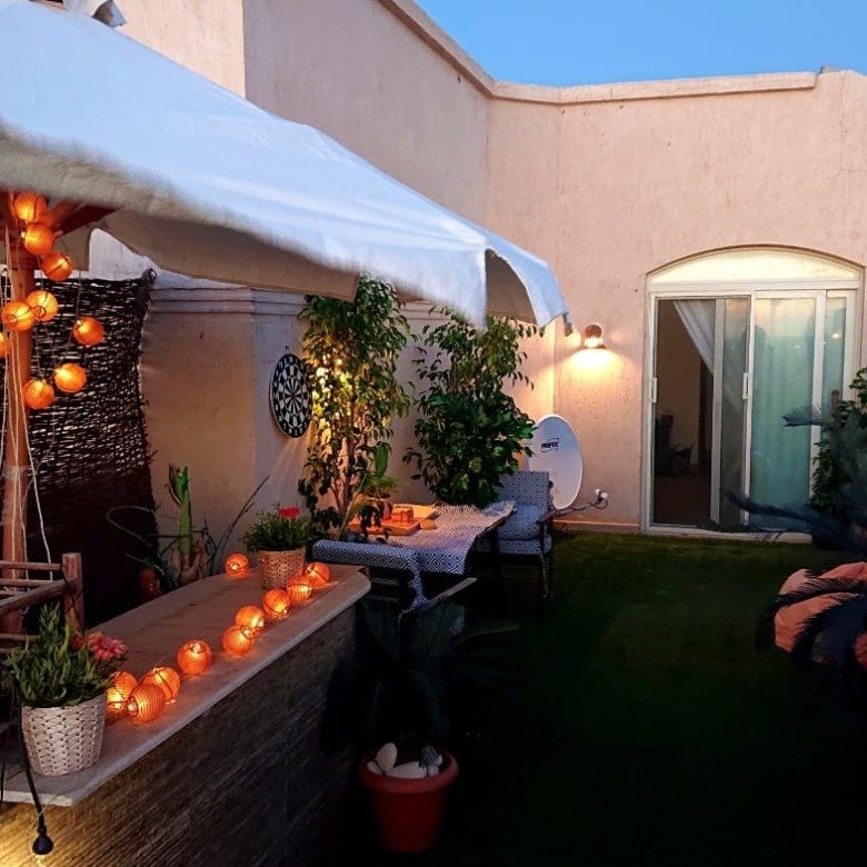 Garden with umbrella and evening lights in the Telal chalet - جاردن بشمسية وإضاءة مسائية في شاليه تلال