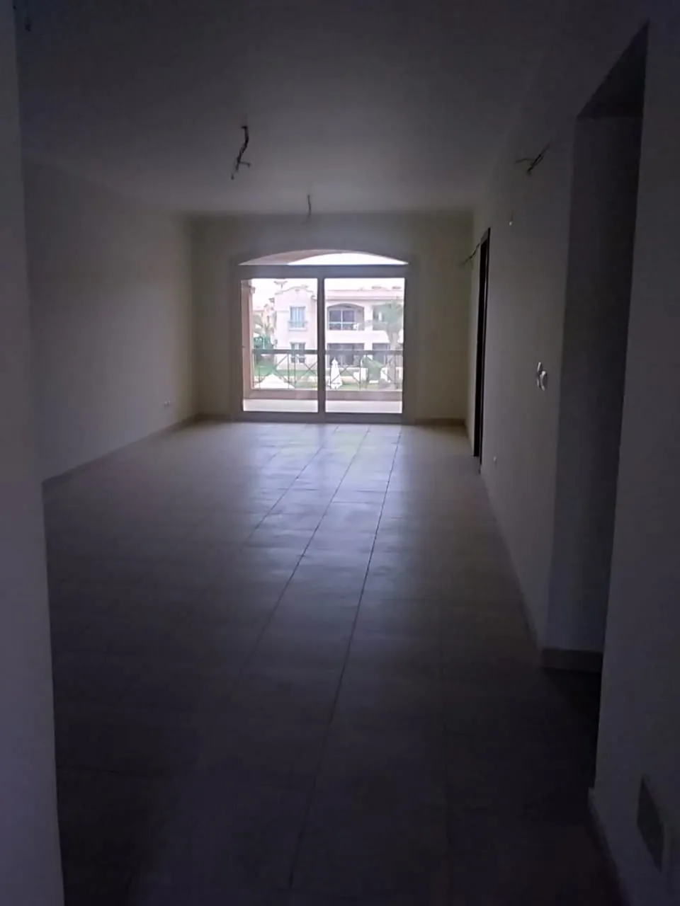 3-bedroom-chalet-for-sale-in-la-vista-topaz غرفة معيشة خالية بأبواب شرفة - شاليه في لافيستا توباز بالعين السخنة