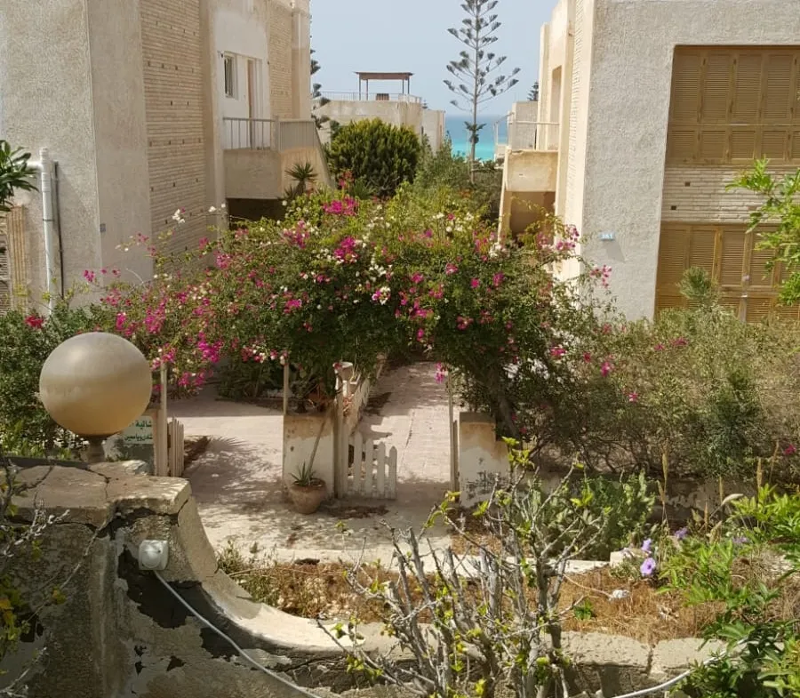 حديقة صخور وشجيرات بجوار بيوت بيضاء - شاليه في بالم هيلز، الساحل الشمالي