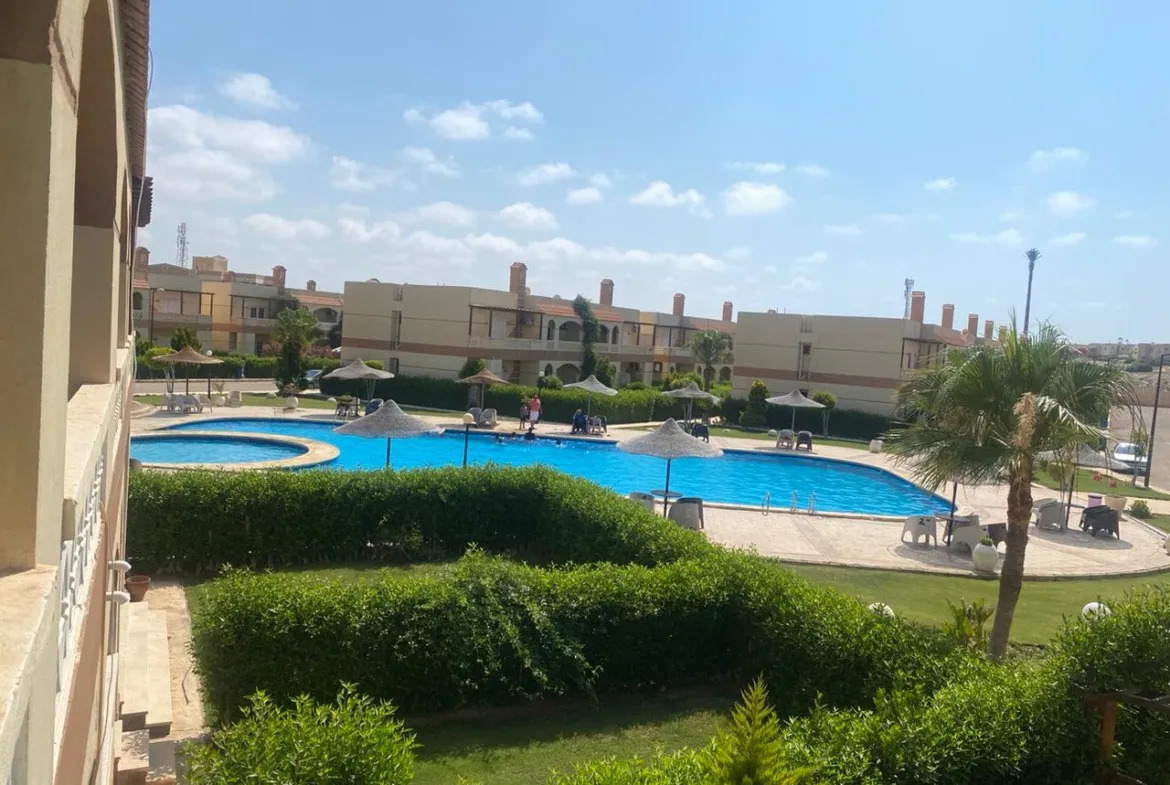 مسبح تحيط به أسوار شجر ومباني سكنية - وحدة في لفلز رأس الحكمة، الساحل الشمالي