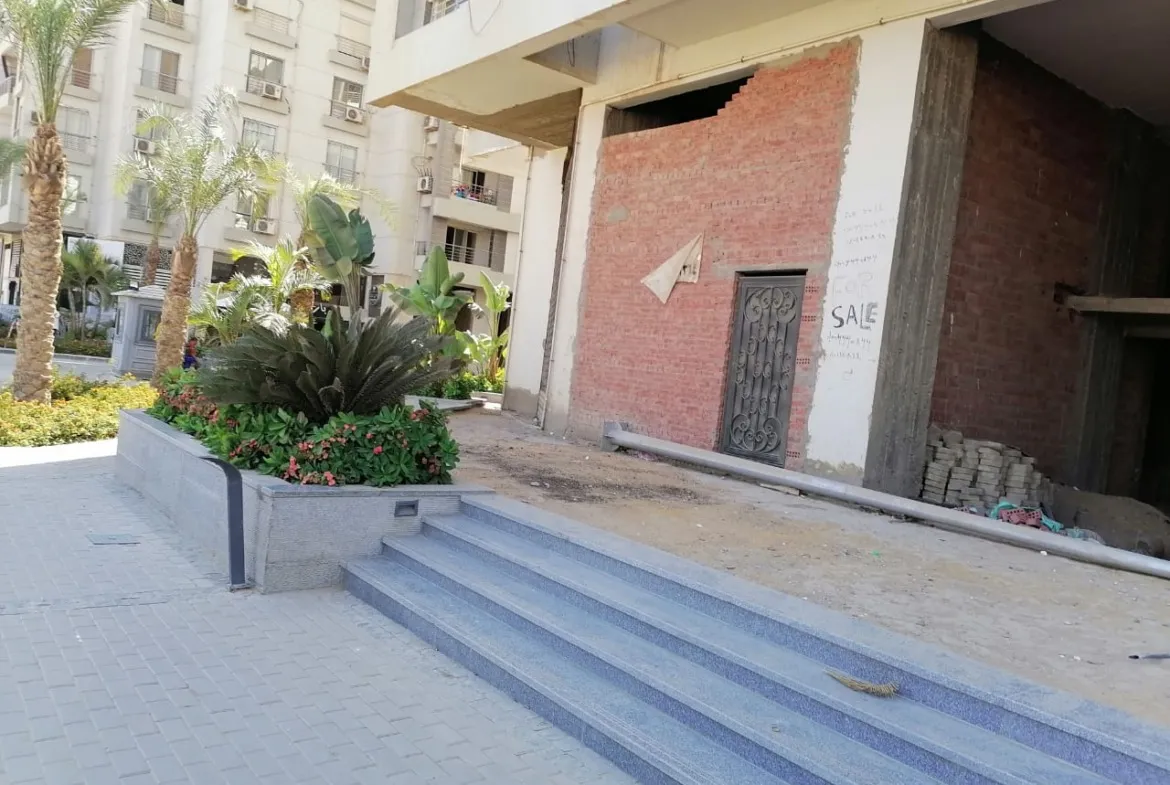 درجات مدخل وأحواض زرع أمام مبنى بطوب ظاهر - تاون هاوس في بافاريا تاون، القاهرة