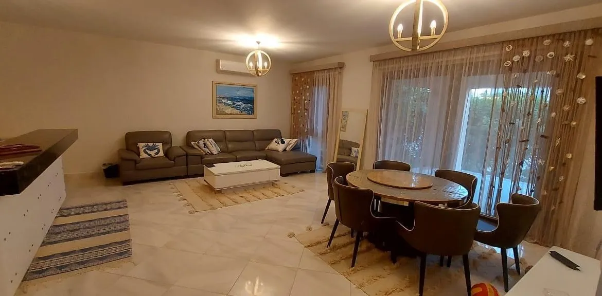 Living and dining room with sliding glass doors in Marassi, North Coast