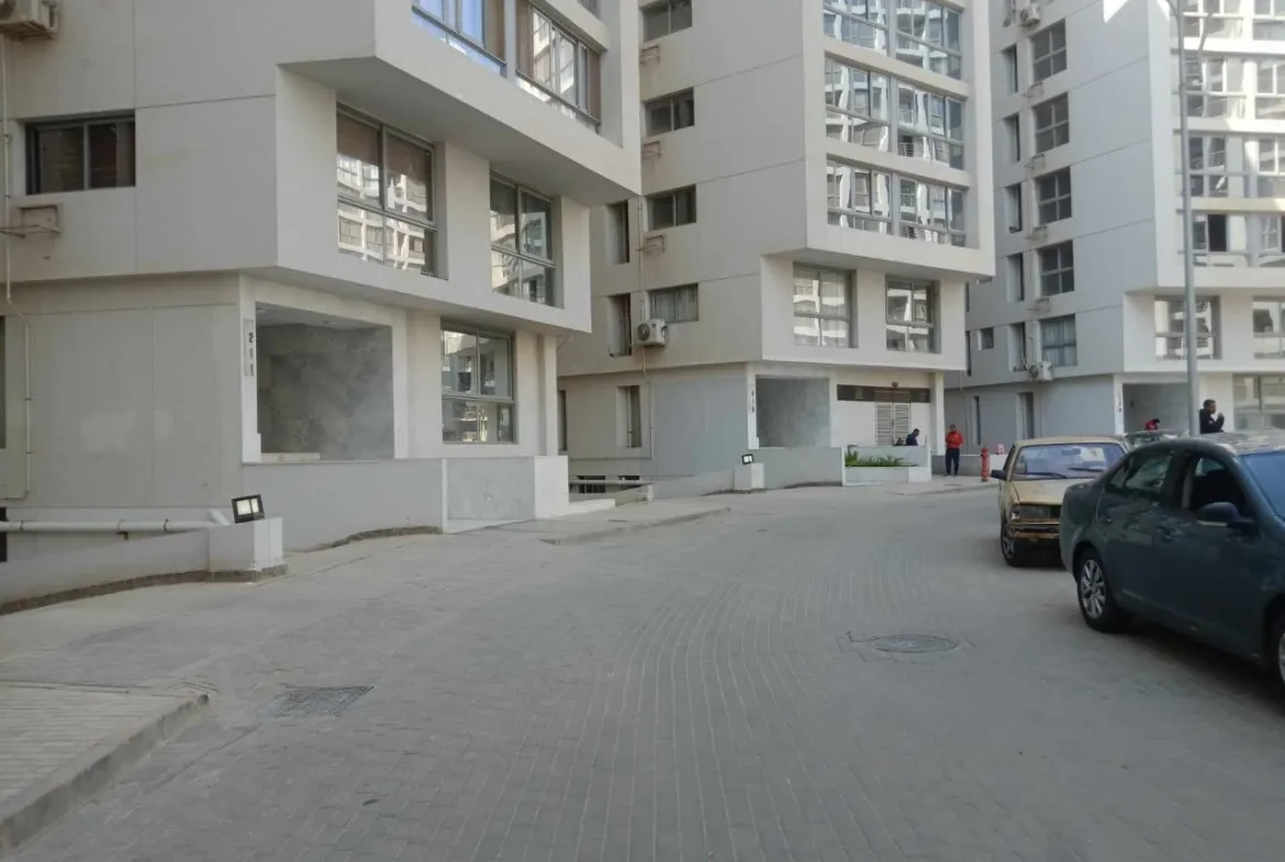 شارع سكني بين عمارات سكنية وسيارات مركونة - شقة في وان قطامية، القاهرة
