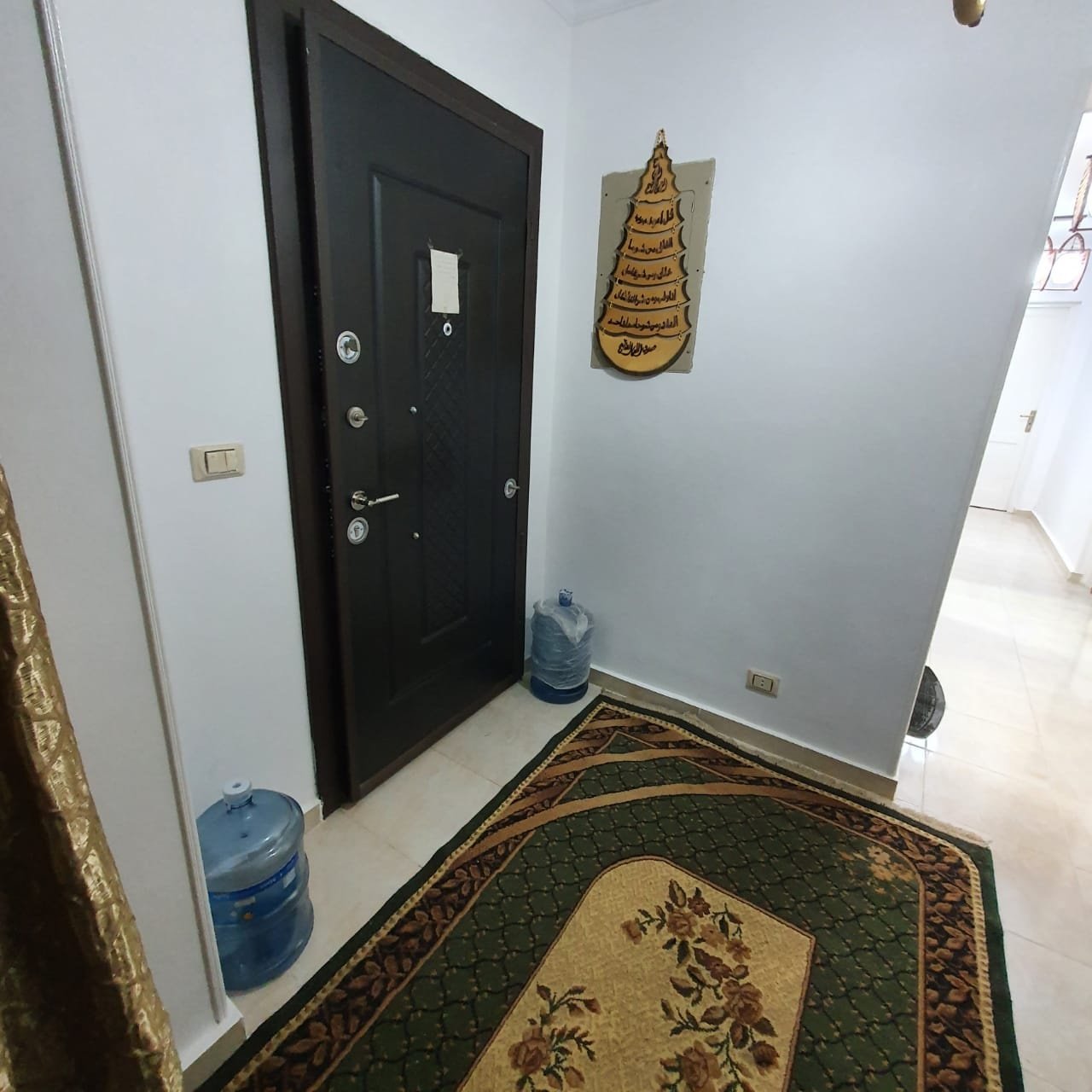 باب رئيسي بسجادة منقوشة وجركن مياه بجواره - شقة في مدينتي، القاهرة الجديدة