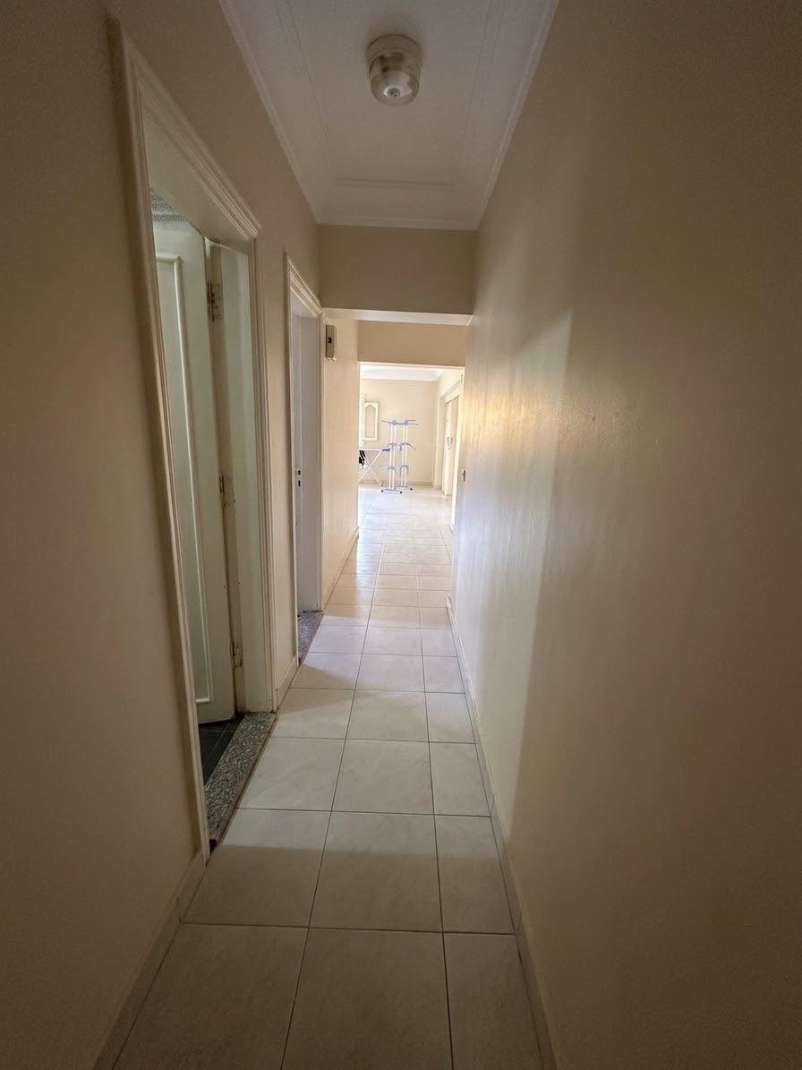 Narrow hallway with a tiled floor and light at the end - apartment in Sahafeen Compound, New Cairo