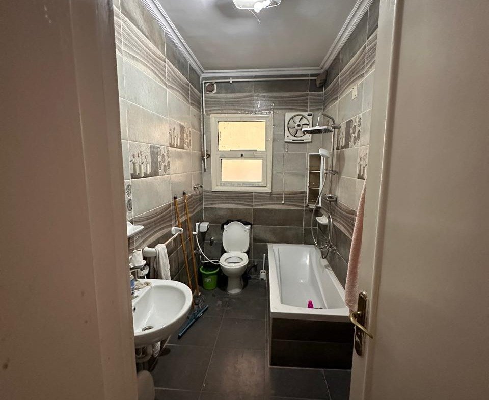 Bathroom seen from the door with a dark floor - apartment in Sahafeen Compound, New Cairo