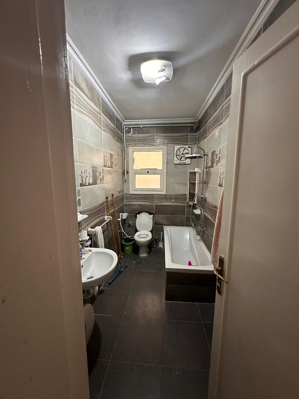 Bathroom seen from the door with a dark floor - apartment in Sahafeen Compound, New Cairo