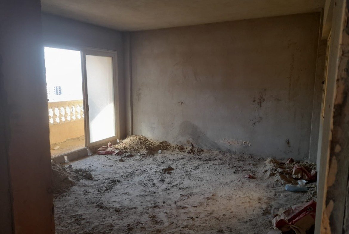 Bare room with a balcony door and rubble on the floor - penthouse in Green House, 5th Settlement