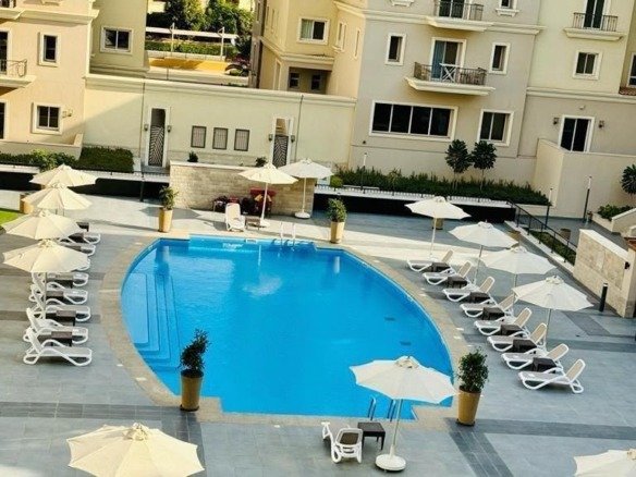 Swimming pool and landscaped courtyard view, apartment for rent in Mivida Boulevard, New Cairo | إطلالة حمام السباحة واللاندسكيب، شقة للإيجار في ميفيدا البوليفارد، القاهرة الجديدة