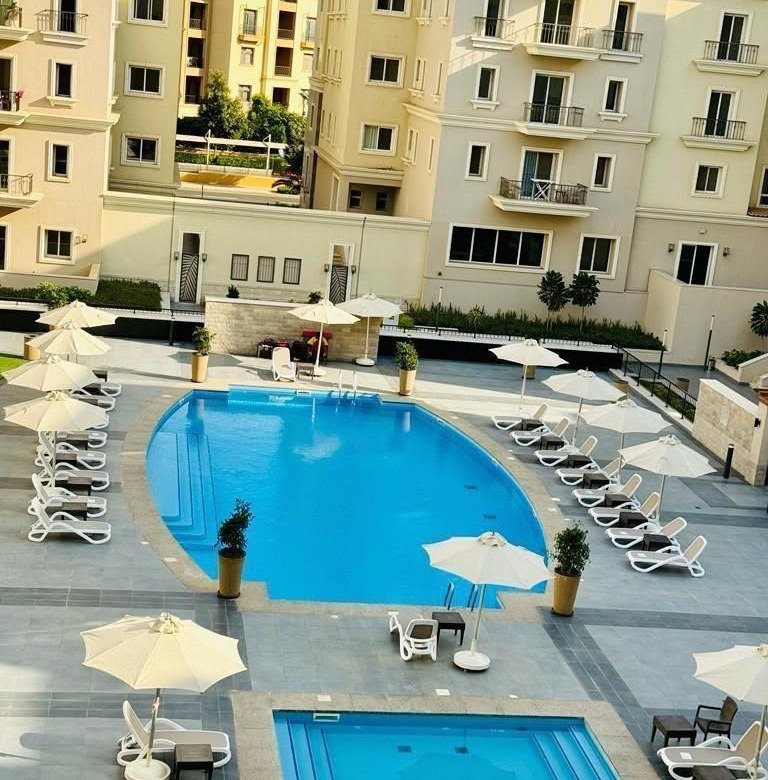 Swimming pool and landscaped courtyard view, apartment for rent in Mivida Boulevard, New Cairo | إطلالة حمام السباحة واللاندسكيب، شقة للإيجار في ميفيدا البوليفارد، القاهرة الجديدة
