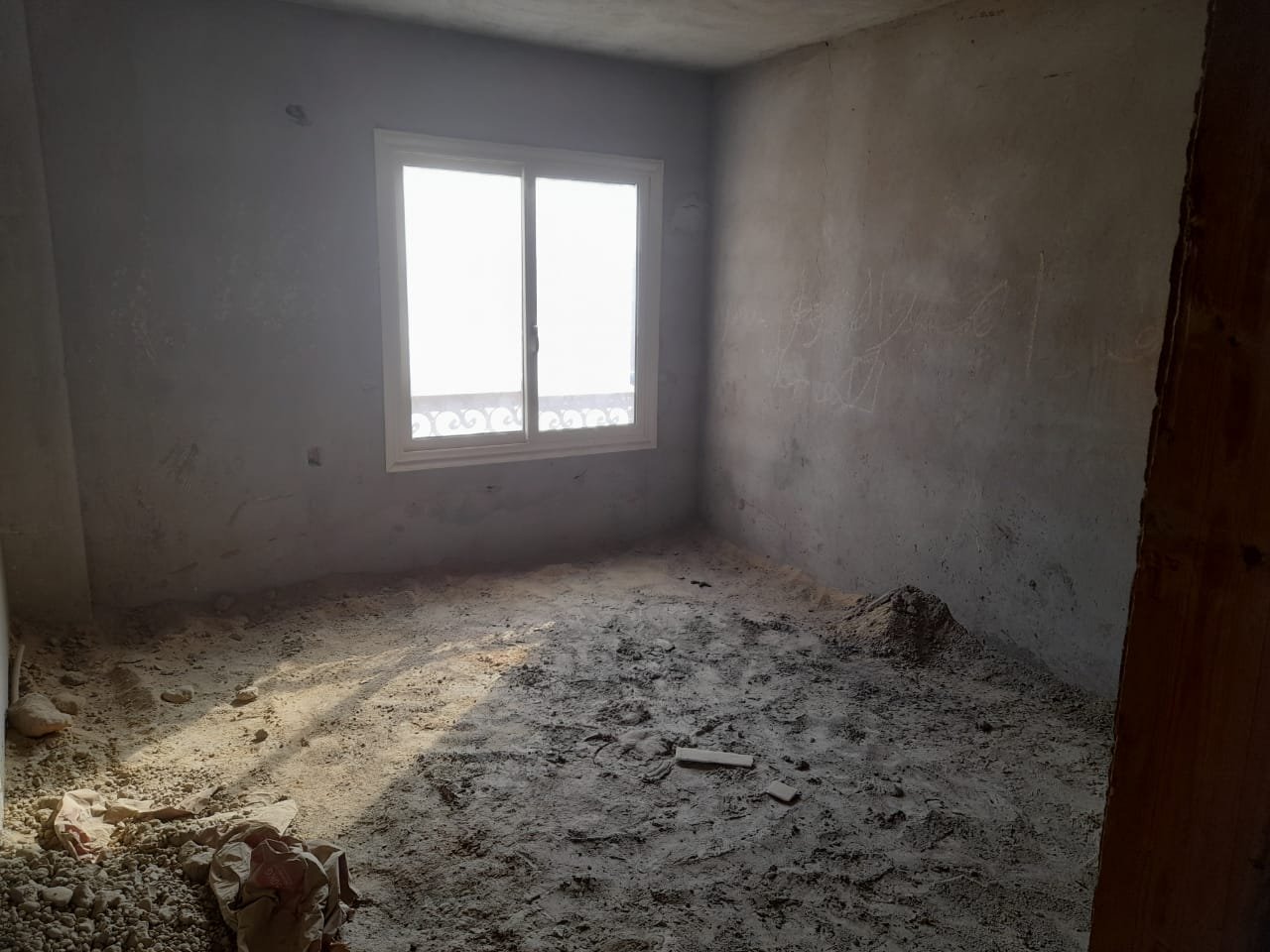 Bare concrete room with a window and a dusty floor - penthouse in Green House, 5th Settlement