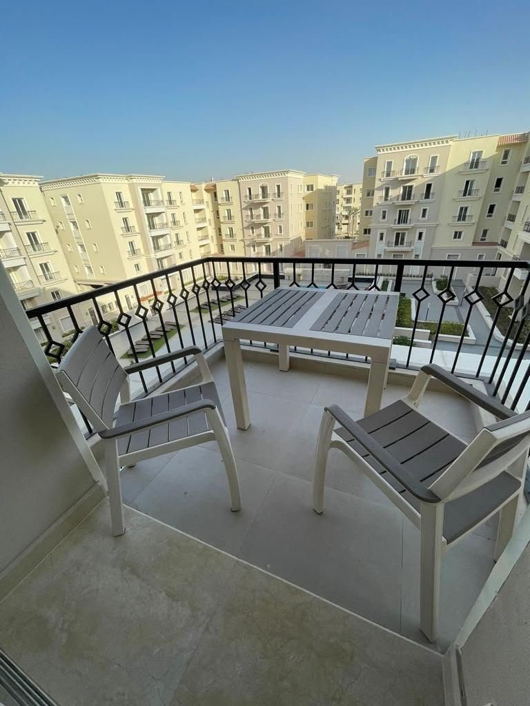 11-mivida-boulevard-apartment-rent-328-01 Terrace seating and pool view, apartment for rent in Mivida Boulevard, New Cairo | جلسة التراس وفيو حمام السباحة، شقة للإيجار في ميفيدا البوليفارد، القاهرة الجديدة