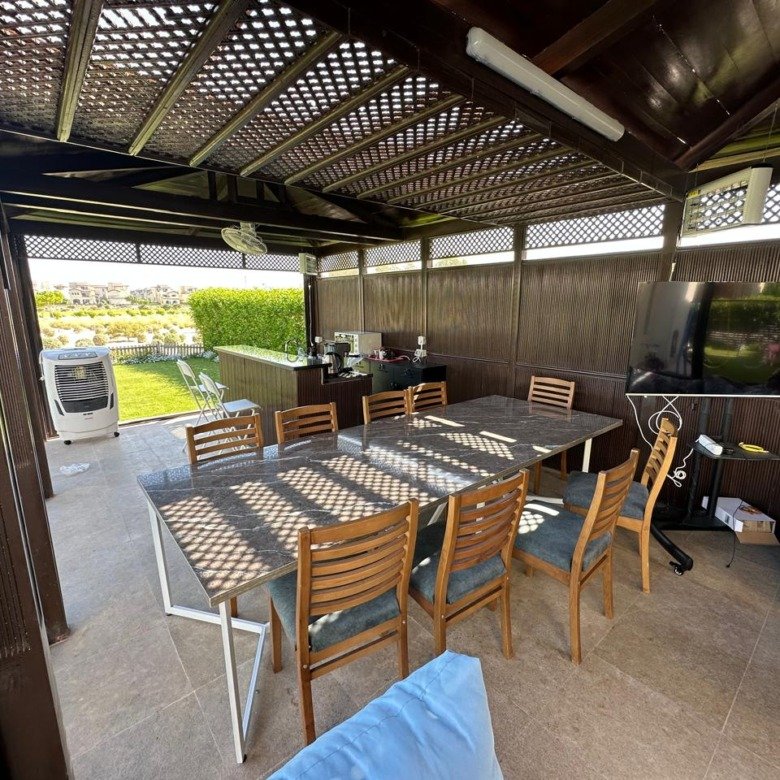 Covered outdoor seating and garden, villa for rent in Marassi Blanca Views, North Coast | جلسة خارجية مغطاة والحديقة، فيلا للإيجار في مراسي بلانكا فيوز، الساحل الشمالي