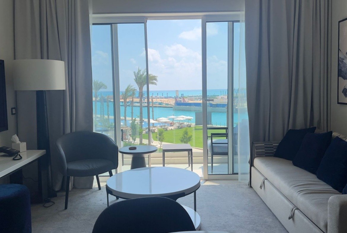 Sofa and coffee table beside balcony doors in Marassi, North Coast
