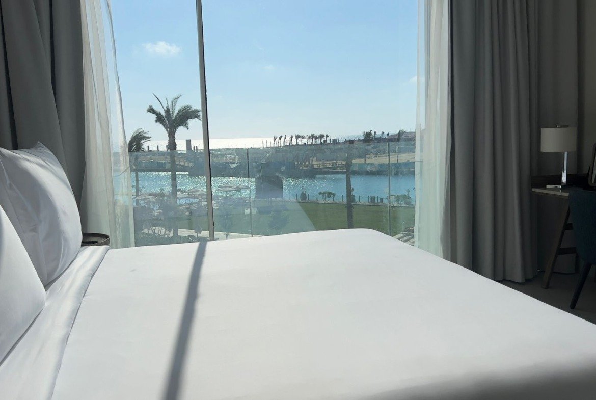 Bed beside a window overlooking the water in Marassi, North Coast