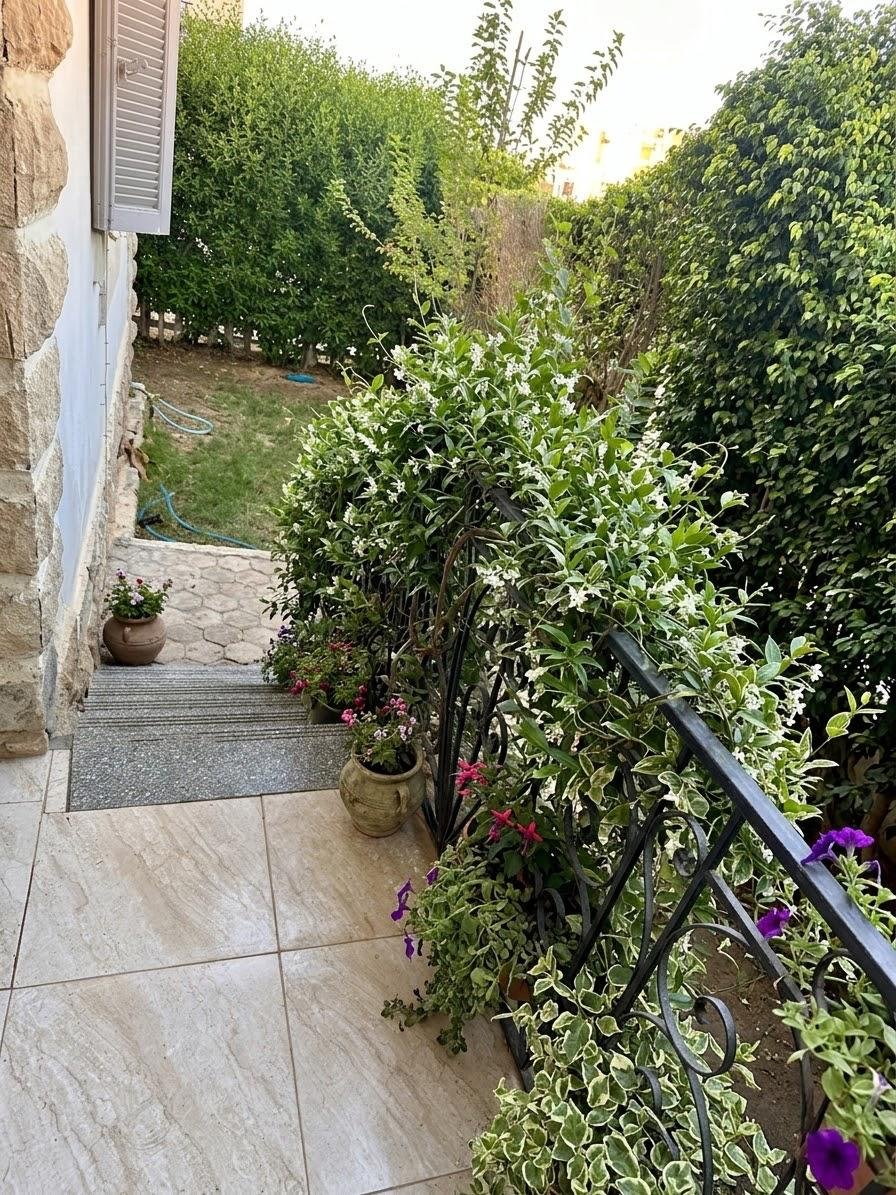 Balcony with potted plants and a black railing - apartment in Sahafeen Compound, New Cairo