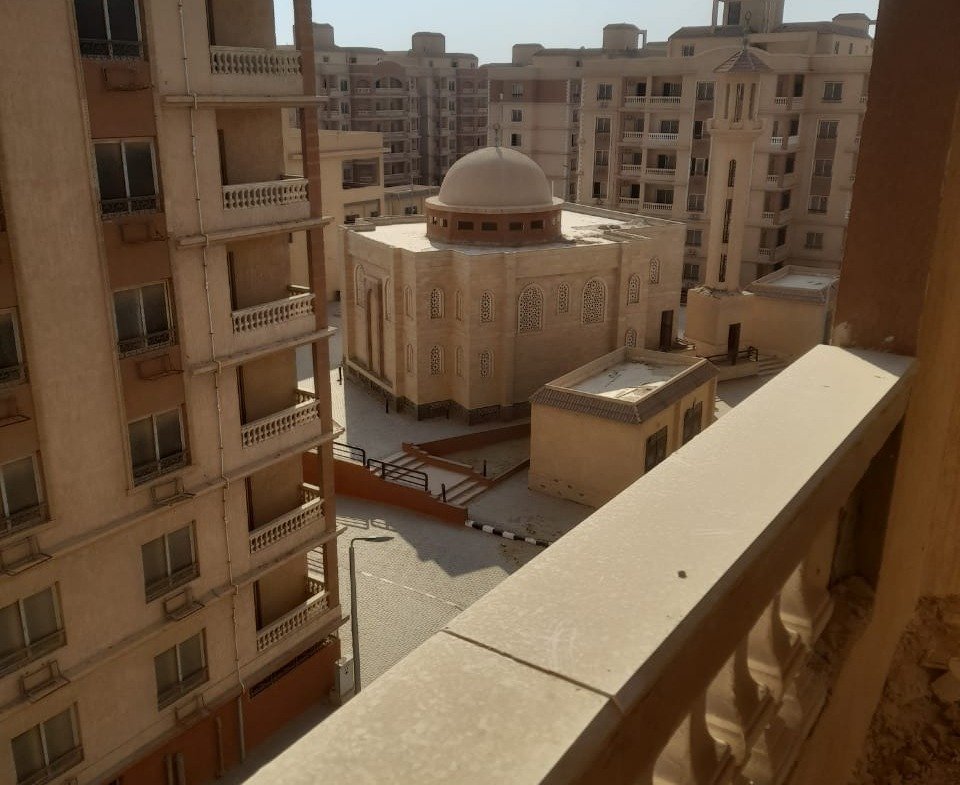 Balcony railing with a view of a domed building and apartment blocks - penthouse in Green House, 5th Settlement