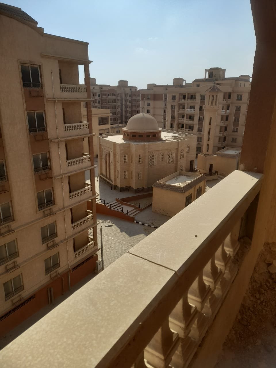 Balcony railing with a view of a domed building and apartment blocks - penthouse in Green House, 5th Settlement