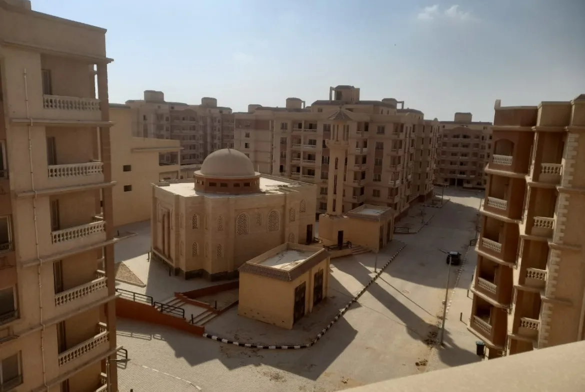 Courtyard view of a domed building between beige apartment blocks - penthouse in Green House, 5th Settlement
