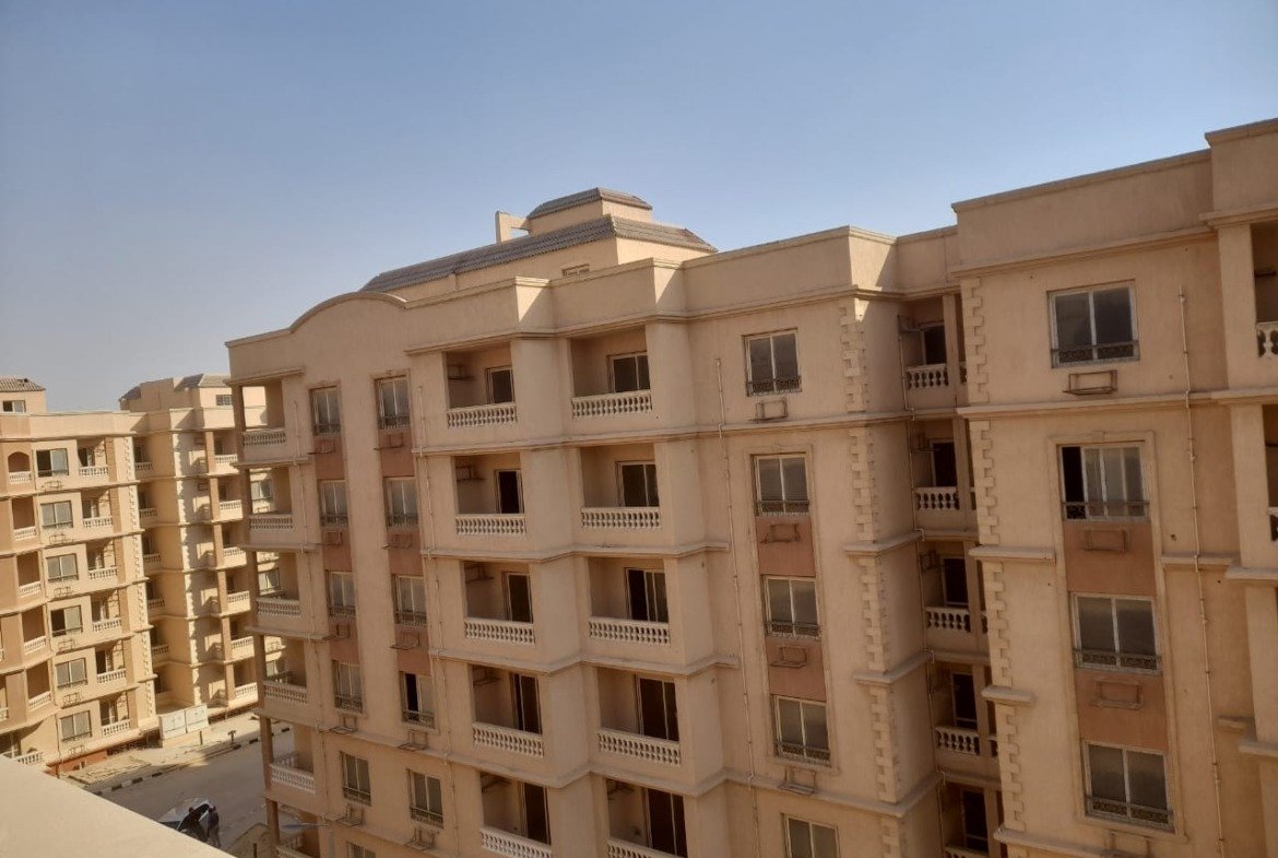Beige apartment building with many balconies against a clear sky - penthouse in Green House, 5th Settlement