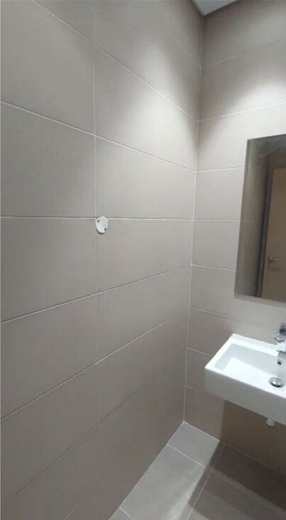 Small washbasin with a wall mirror in a grey restroom - office in Cairo Festival City, New Cairo