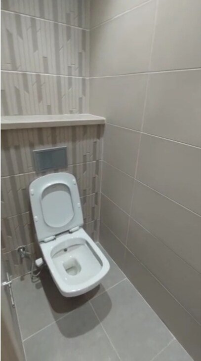 Wall-hung toilet with a tiled accent wall - office in Cairo Festival City, New Cairo