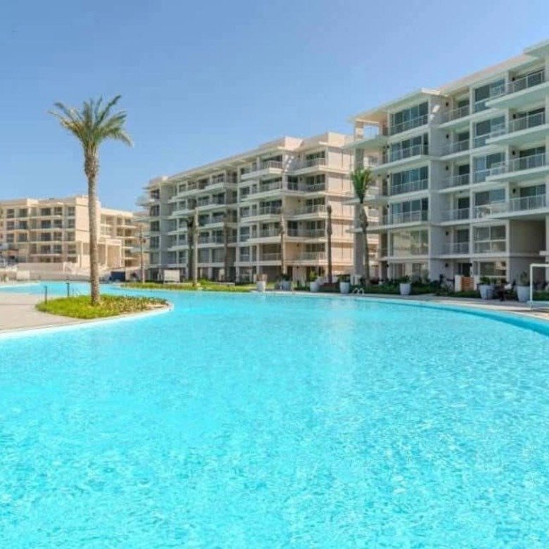 Lagoon and apartment buildings in daylight, chalet for rent in Marassi Marina Views, North Coast | اللاجون والمباني في النهار، شاليه للإيجار في مراسي مارينا فيوز، الساحل الشمالي